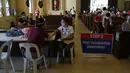 Petugas kesehatan memeriksa seorang perempuan setelah diinokulasi dengan vaksin COVID-19 AstraZeneca di dalam gereja Paroki Hati Kudus Yesus di Quezon City, Filipina, Senin (17/5/2021). Gereja itu digunakan untuk mempercepat proses vaksinasi kepada warga di daerah tersebut. (AP Photo/Aaron Favila)