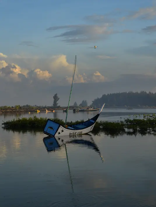 Sebuah perahu kayu nelayan terlihat pada Hari Bumi di pantai Kajhu, provinsi Aceh (22/4/2021). Hari Bumi adalah acara tahunan yang dirayakan di seluruh dunia pada 22 April untuk menunjukkan dukungan bagi perlindungan lingkungan. (AFP/Chaideer Mahyuddin)