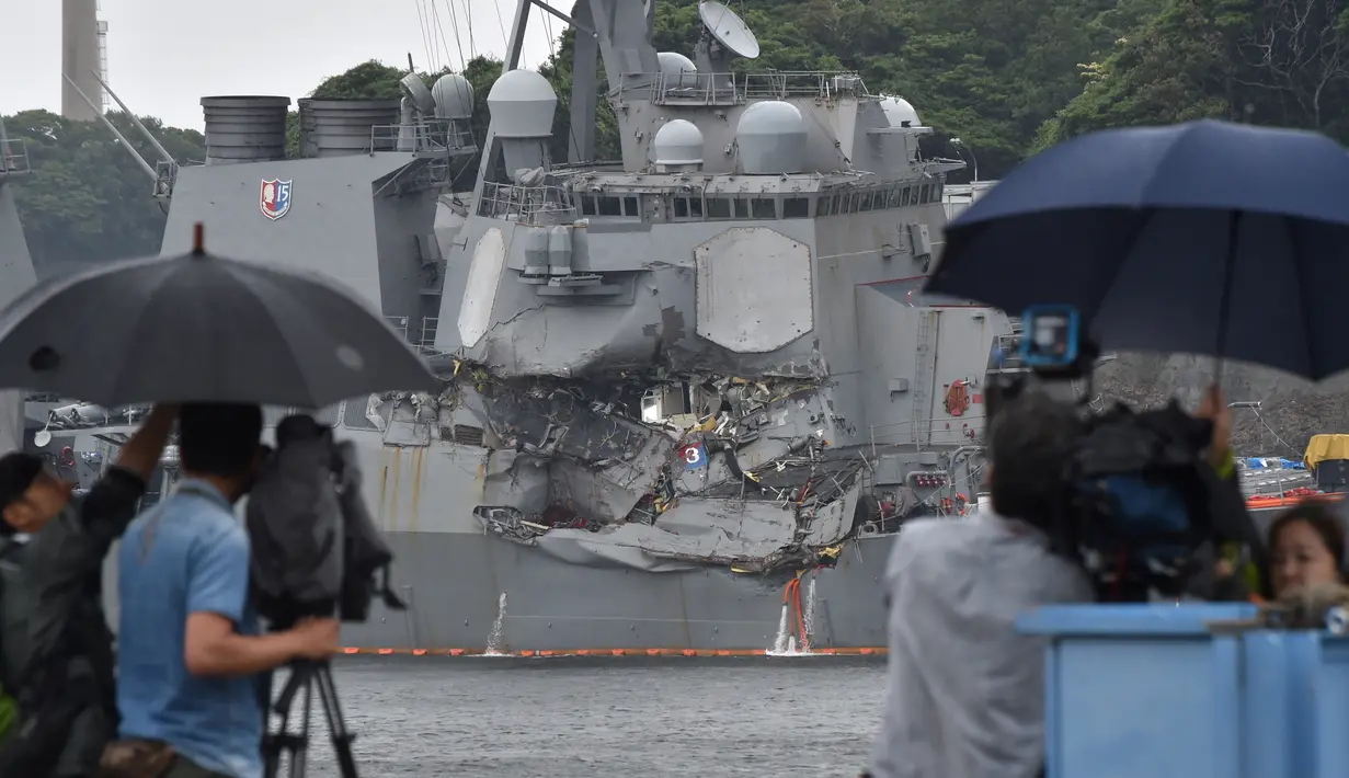 Sejumlah awak media meliput kapal perusak USS Fitzgerald yang bertabrakan dengan kapal dagang di pelabuhan Yokosuka, Jepang (17/6). (AFP Photo/Kazuhiro Nogi)