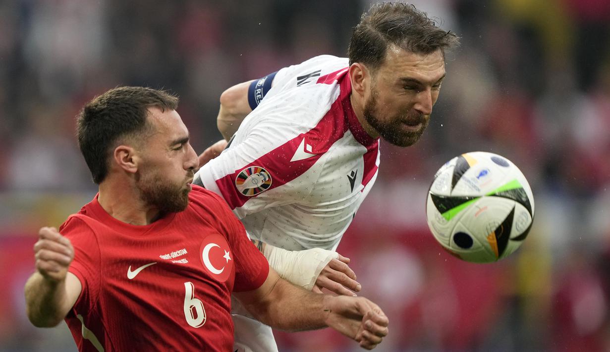 Bek Timnas Georgia, Guram Kashia (kanan) berduel udara dengan gelandang Timnas Turki, Orkun Kokcu pada laga matchday pertama Grup F Euro 2024 di Westfalenstadion, Dortmund, Jerman, Selasa (18/6/2024). (AP Photo/Martin Meissner)