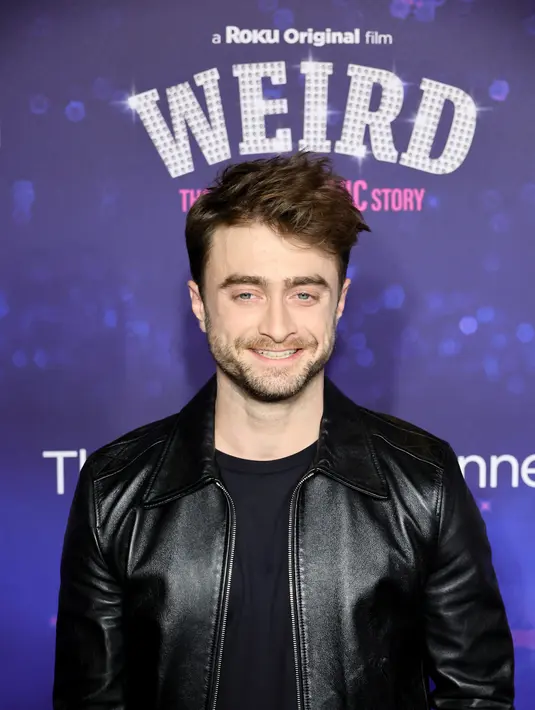 Daniel Radcliffe berpose sambil tersenyum saat menghadiri pemutaran perdana film "Weird: The Al Yankovic Story" di Alamo Drafthouse Cinema Downtown Brooklyn di New York pada Selasa, 1 November 2022. Radcliffe melanjutkan dengan tema hitam, mengenakan sepasang sepatu untuk acara tersebut. (Theo Wargo/Getty Images/AFP)