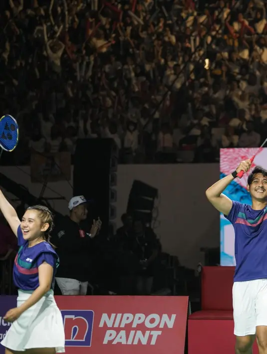 Ia mengenakan jersey biru dengan stripe pink hijau dan rok mini khas pebulutangkis [@arya.saloka]