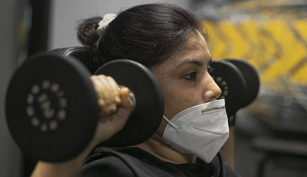 Seorang wanita India berolahraga di gym yang dibuka kembali setelah lockdown di Gauhati, India, Rabu, (5/8/2020). India memiliki jumlah virus coronavirus tertinggi ketiga di dunia setelah Amerika Serikat dan Brasil. (AP Photo/Anupam Nath)
