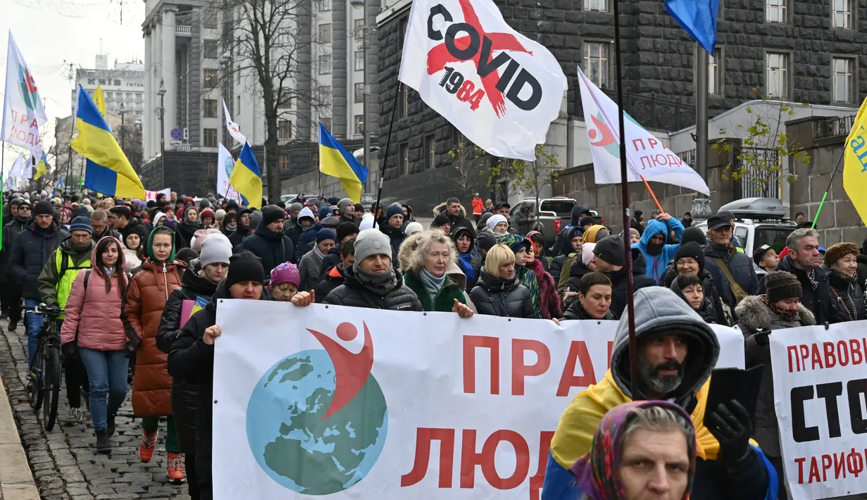 Demonstran anti-vaksin berunjuk rasa di Kiev (24/11/2021). Ratusan pengunjuk rasa memblokir jalan-jalan di pusat kota Kiev pada 24 November untuk berdemonstrasi menentang langkah-langkah anti-Covid Ukraina dan upaya vaksin, saat negara itu memerangi gelombang infeksi baru. (AFP/Genya Savilov)