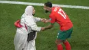 Pemain Maroko, Sofiane Boufal (kanan) merayakan kemenangan bersama ibunya setelah timnya berhasil mengalahkan Portugal pada laga perempat final Piala Dunia 2022 yang berlangsung di Al Thumama Stadium, Qatar, 10 Desember 2022. (AP Photo/Luca Bruno)