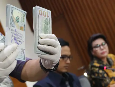Petugas memperlihatkan uang yang berhasil disita dari pejabat PT PAL terkait dugaan suap pengadaan kapal ke Filipina, Jakarta, Jumat (31/3). KPK menyita 25 ribu dolar AS dan menahan 4 tersangka. (Liputan6.com/Helmi Afandi)