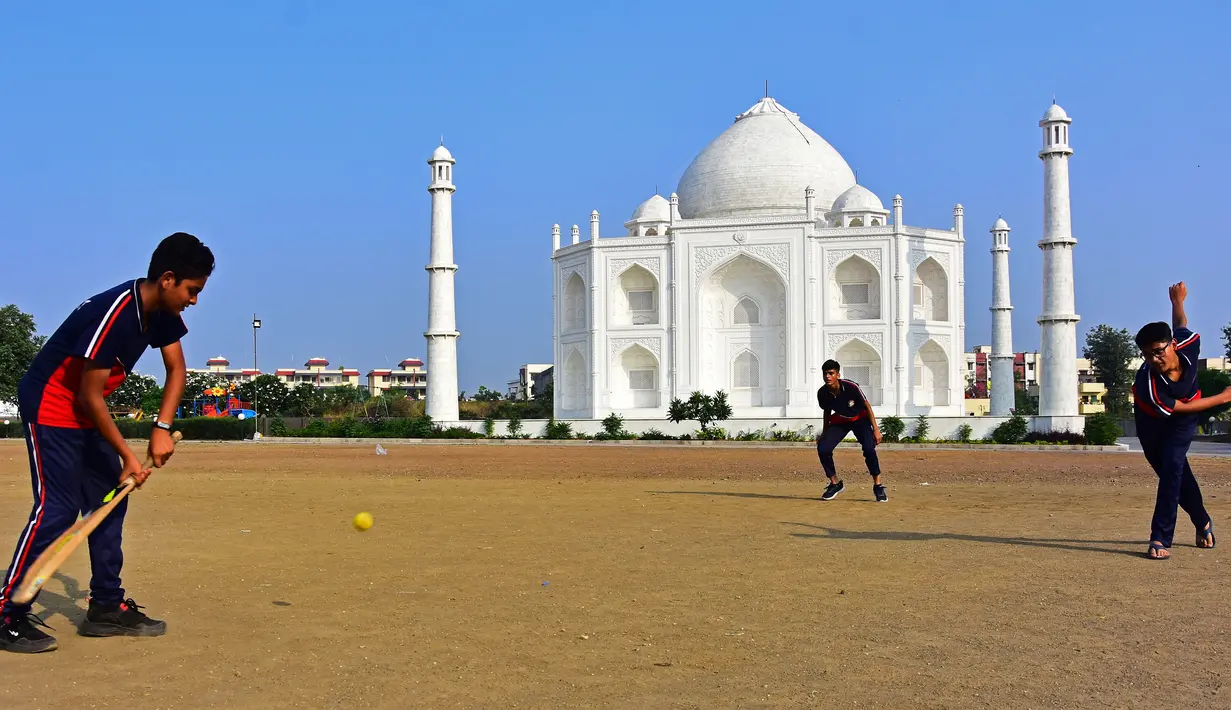 Dalam foto pada 25 November 2021, anak laki-laki bermain kriket di depan replika Taj Mahal di Burhanpur di negara bagian Madhya Pradesh. Pengusaha India Anand Prakash Chouksey menghabiskan waktu hingga tiga tahun membangun replika Taj Mahal untuk istrinya tersebut. (Uma Shankar MISHRA / AFP)