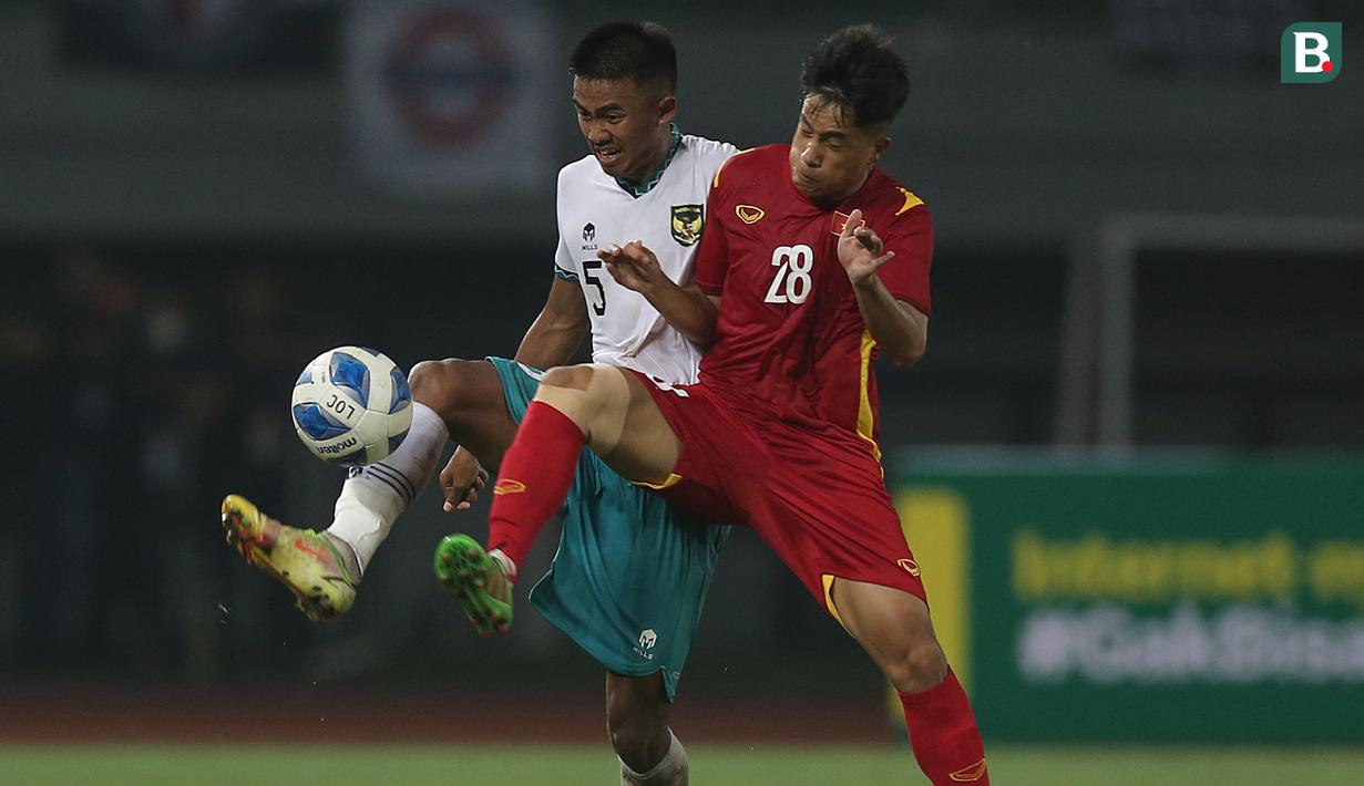 <p>Pemain Timnas Indonesia U-19, Kakang Rudianto (kiri) berebut bola dengan pemain Timnas Vietnam U-19, Nguyen Gian Tan saat laga Grup A Piala AFF U-19 2022 antara Timnas Indonesia U-19 melawan Timnas Vietnam U-19 di Stadion Patriot Candrabhaga, Bekasi, Jawa Barat, Sabtu (02/07/2022). (Bola.com/Ikhwan Yanuar)</p>