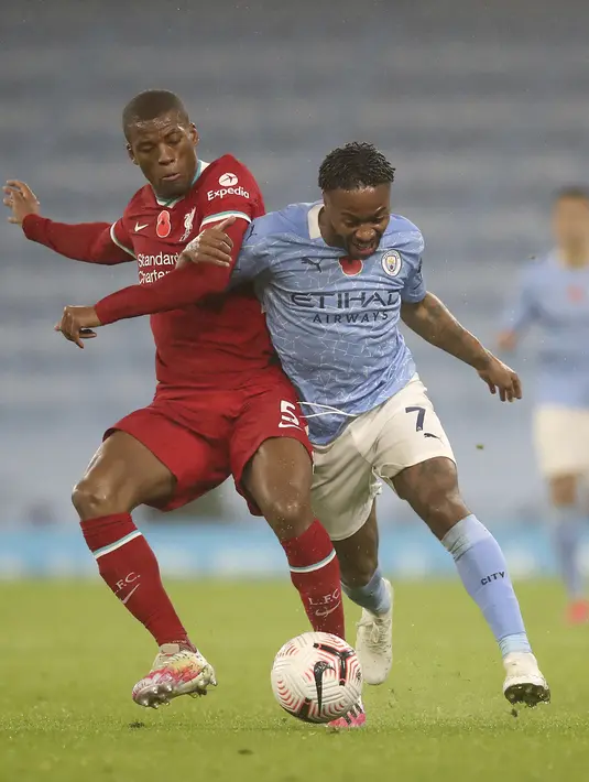 Penyerang Manchester City, Raheem Sterling dan gelandang Liverpool, Georginio Wijnaldum berebut bola pada pertandingan Liga Inggris pekan ke-8 di Etihad Stadium, Minggu (8/11/2020). City gagal mengalahkan Liverpool dan harus puas berbagi angka setelah bermain imbang 1-1. (Martin Rickett/Pool via AP)