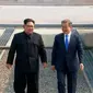 Pemimpin Korea Utara Kim Jong-un dan Presiden Korea Selatan Moon Jae-in berjalan melewati Zona Demiliterisasi, Jumat (27/4). Kim dan Moon menuju Rumah Perdamaian di wilayah Korsel untuk menggelar pertemuan tingkat tinggi (Korea Broadcasting System via AP)