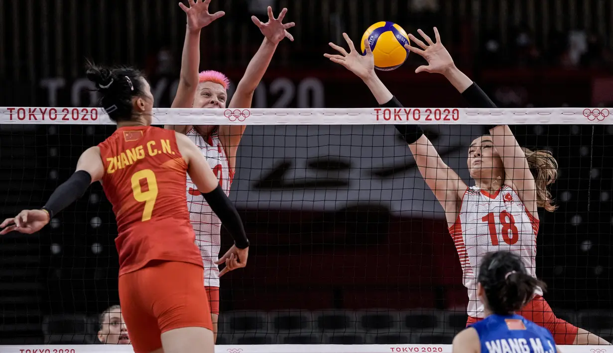 Atlet Voli Turki, Zehra Gunes memblok bola pemain China pada pertandingan penyisihan grup B bola voli putri Olimpiade Tokyo 2020 di Tokyo, Jepang (25/7/2021). Parasnya yang menawan dan kemampuannya main voli membuatnya dipuja baik di dunia nyata maupun di media sosial. (AP Photo/Manu Fernandez)
