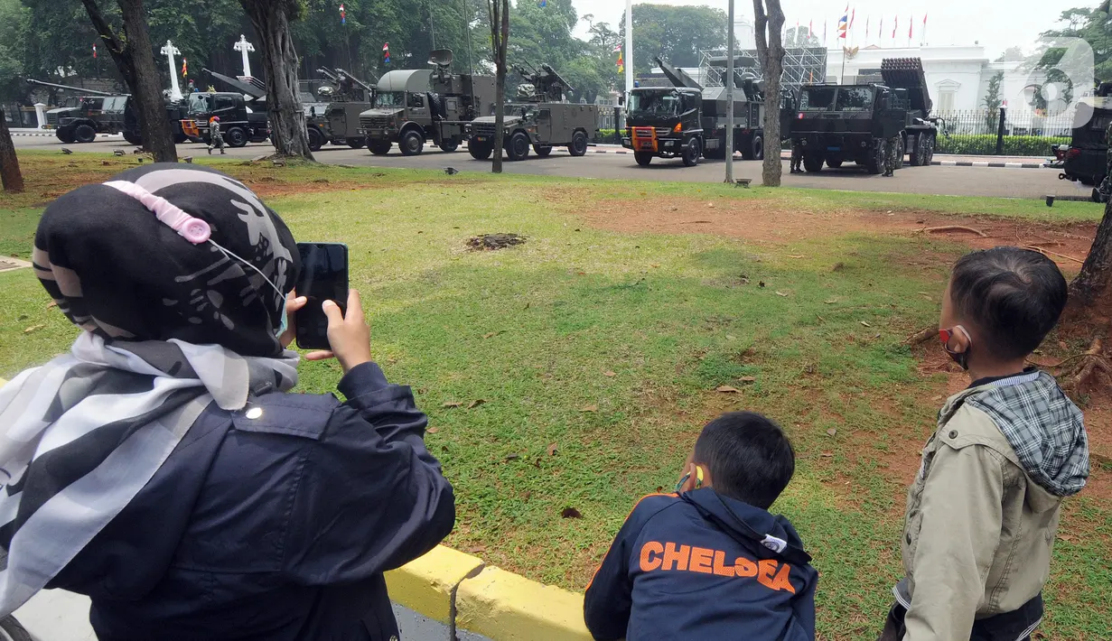Warga mengambil gambar kendaraan taktis TNI yang dipamerkan di depan Istana Merdeka, Jakarta, Senin (4/10/2021). Ratusan alat utama sistem persenjataan (Alutsista) TNI dipamerkan sepanjang pinggir jalan sekeliling kawasan Monas dalam rangka peringatan HUT ke-76 TNI. ​(merdeka.com/Arie Basuki)