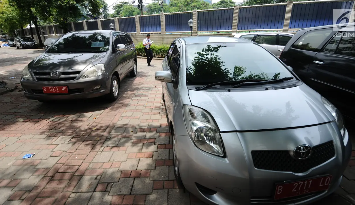 Petugas keamanan mengecek mobil operasional KPK yang akan dilelang di Gedung KPK Lama, Jakarta, Selasa (27/2). KPK akan melelang kendaraan operasional inventaris yang telah berumur di atas 10 tahun. (Liputan6.com/Helmi Fithriansyah)