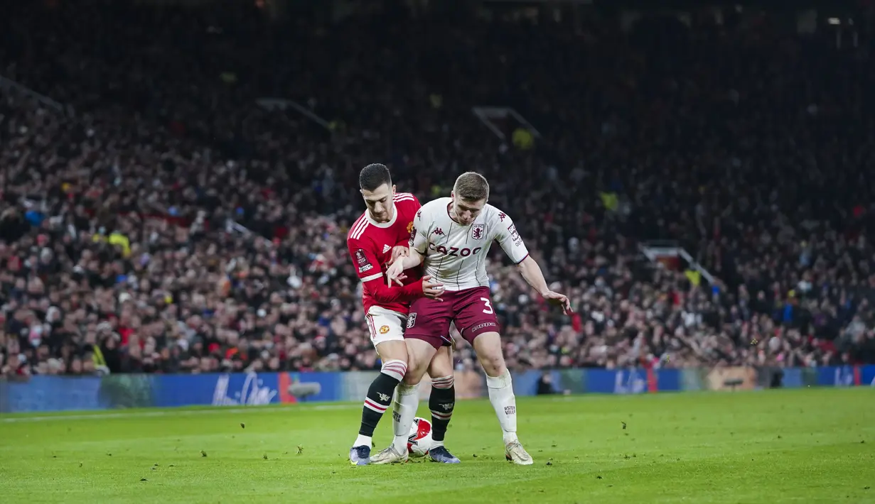 Bek Manchester United, Diogo Dalot berebut bola dengan pemain Aston Villa, Matt Targett pada pertandingan putaran ketiga Piala FA di stadion Old Trafford di Manchester, Inggris, Selasa (11/1/2022). Berkat hasil ini, MU berhak lolos ke putaran keempat dan akan menghadapi Middlesbrough. (AP Photo/Jon