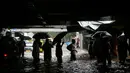 Sejumlah orang menerobos banjir yang merendam jalanan kota Mumbai, India, Selasa (29/8). Hujan lebat diperkirakan terus berlanjut selama 24 jam ke depan dan memaksa ratusan warga untuk tinggal di dalam rumah. (AP Photo/Rajanish Kakade)