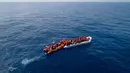 Momen saat LSM Proactiva Open Arms Spanyol menyelamatkan pengungsi dan imigran di utara pantai Libya, Minggu (6/5). Para pengungsi dan imigran menaiki perahu karet yang penuh sesak. (AP Photo/Felipe Dana)