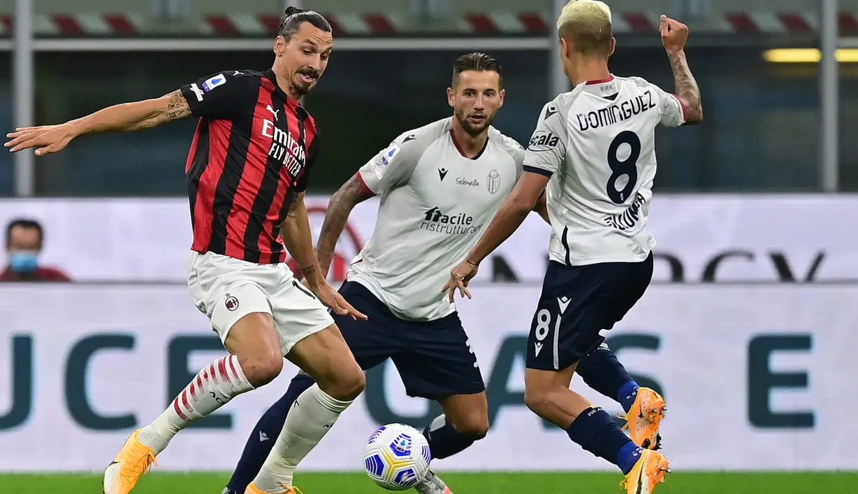 Penyerang AC Milan, Zlatan Ibrahimovic, berusaha melewati pemain Bologna pada laga Liga Italia di Stadion San Siro, Selasa (22/9/2020) dini hari WIB. AC Milan menang 2-0 atas Bologna. (AFP/Miguel Medina)