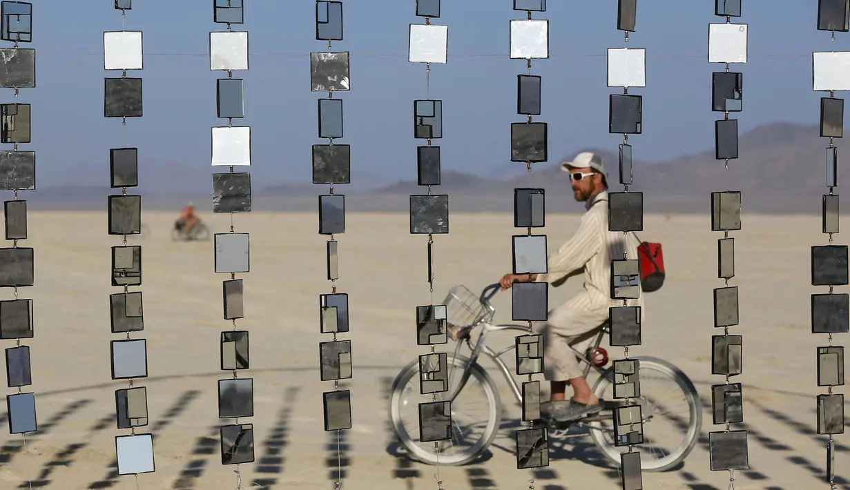 Seorang pria saat menikmati sebuah instalasi seni selama gelaran The Burning Man 2015 " Carnival of Mirrors " di sebuah gurun pasir, Nevada,(31/8/2015). Acara ini akan berlangsung selama seminggu penuh. (REUTERS/Jim Urquhart)