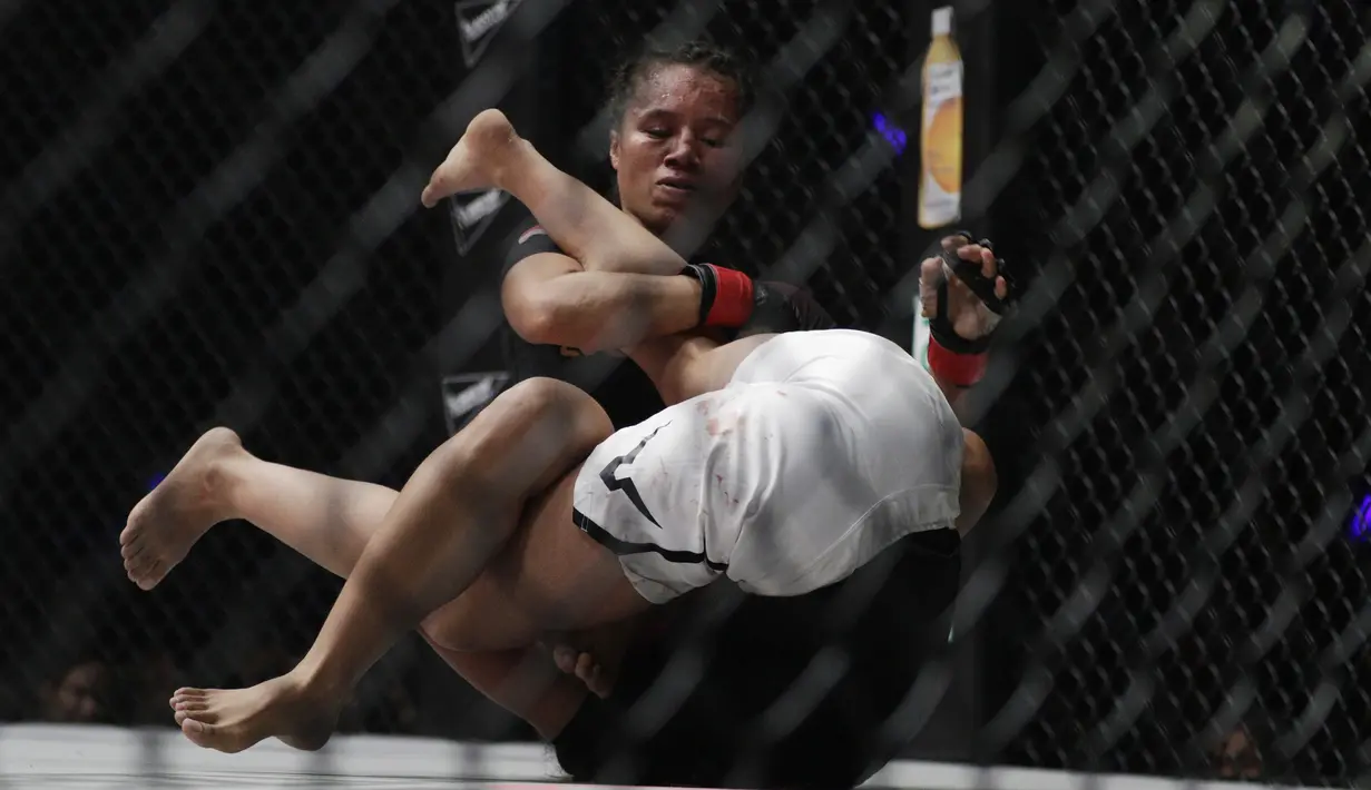 Petarung Indonesia, Priscilla Lumban Gaol, mengunci petarung India, Puja Tomar, saat bertarung pada laga ONE Championship di Istora Senayan, Jakarta, Sabtu (19/1). Priscilla kalah dari Puja. (Bola.com/M. Iqbal Ichsan)