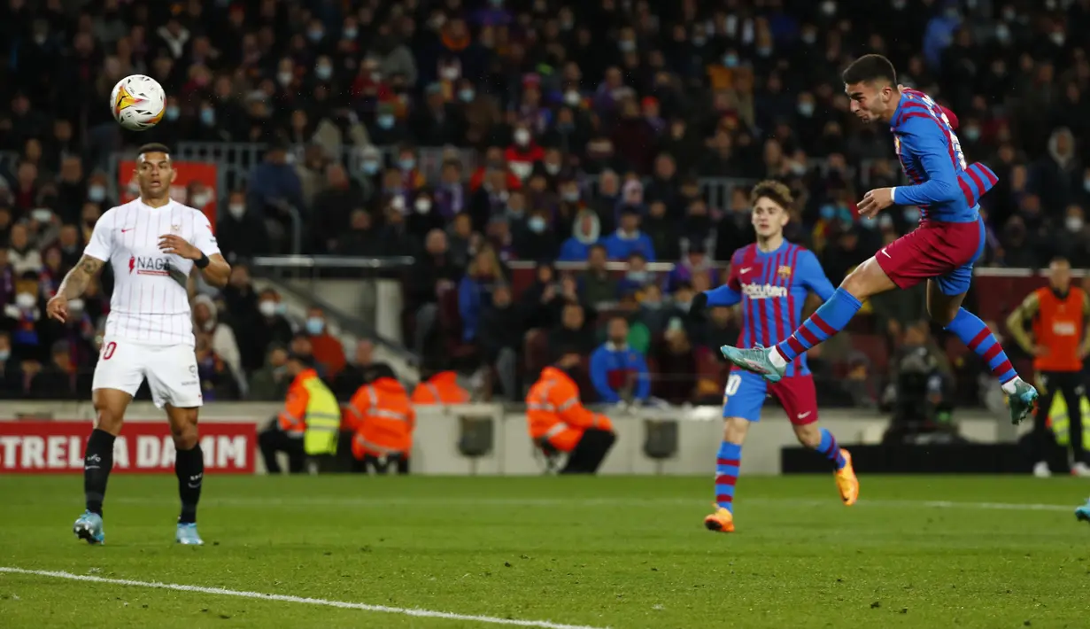 Penyerang Barcelona, Ferran Torres menyundul bola ke gawang Sevilla pada pertandingan lanjutan La Liga Spanyol di stadion Camp Nou di Barcelona, Spanyol, Senin (4/4/2022). Barcelona menang tipis atas Sevilla 1-0. (AP Photo/Joan Monfort)