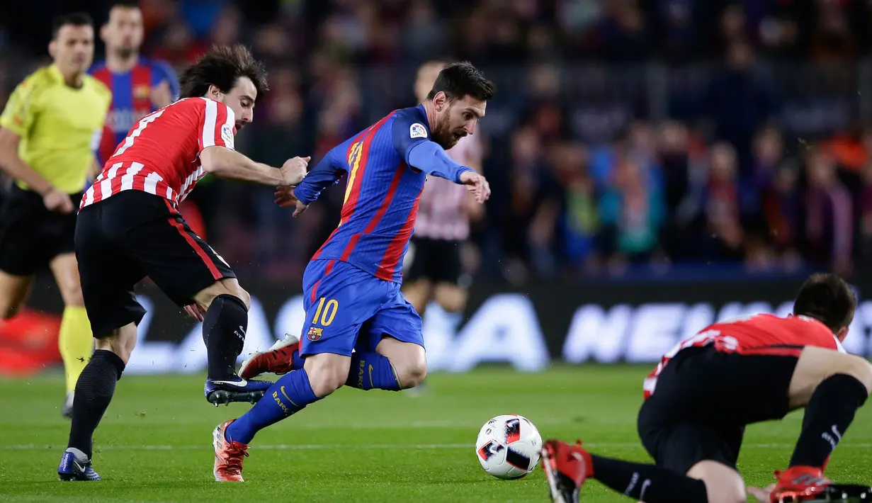 Penyerang Barcelona, Lionel Messi berusaha melewati pemain Athletic Bilbao saat pertandingan Piala Raja di Camp Nou, Barcelona, Kamis (12/1). Barcelona menang 3-1 atas Bilbao. (AP/Manu Fernandez)