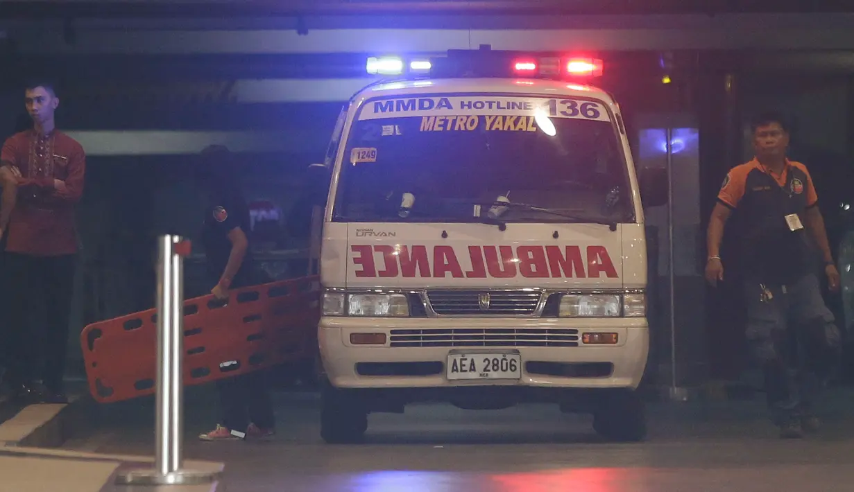Petugas medis membawa tandu masuk ke dalam area hotel di kompleks Resorts World Manila, Filipina, Jumat (2/6). Seorang pria bersenjata ditemukan bunuh diri usai menyerang ruang kasino dengan beberapa kali tembakan. (AP Photo/Aaron Favila)