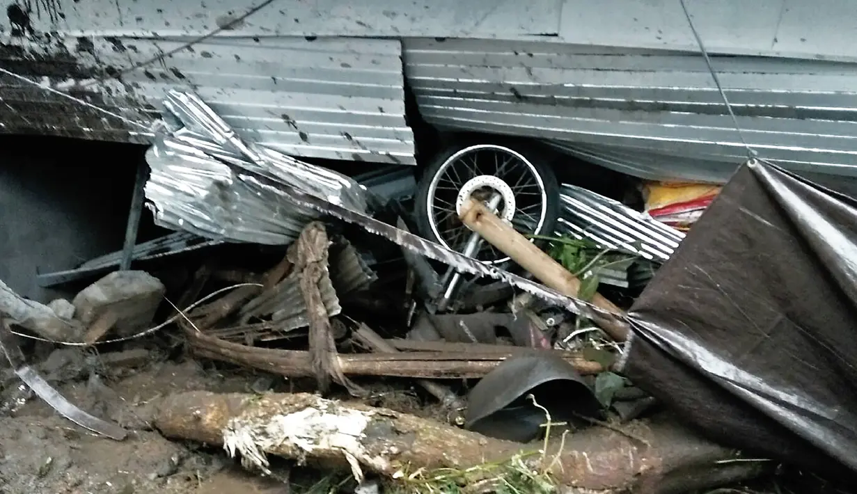 Sepeda motor tertimpa reruntuhan rumah yang ambruk akibat tanah longsor di Kecamatan Kintamani, Bali, Jumat (10/2). Hujan deras sepanjang Kamis malam menyebabkan longsor di tiga desa di Kecamatan Kintamani. (STR/NATIONAL DISASTER AGENCY/AFP)