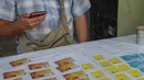 Seorang pedagang kaki lima memamerkan kartu SIM seluler di Yangon, Myanmar (4/2/2021).  Militer Myanmar melakukan kudeta dan Senin 1 Februari dan menahan sejumlah tokoh termasuk Aung San Suu Kyi. (AP Photo)