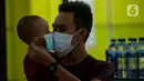 Calon penumpang kereta api mengenakan masker saat berada di Stasiun Gambir, Jakarta Pusat, Jumat (31/01). Dalam rangka pencegahan Virus Corona, PT Kereta Api Indonesia (persero) melakukan sosialisasi kepada penumpang dengan membagi-bagikan masker di stasiun Gambir. (merdeka.com/Imam Buhori)