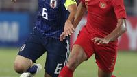 Bek Timnas Indonesia U-19, Asnawi Mangkualam (kanan) berebut bola dengan pemain Jepang, Saito Mitsuki pada perempat final Piala AFC U-19 2018 di Stadion GBK, Jakarta, Minggu (28/10). Indonesia kalah 0-2. (Liputan6.com/Helmi Fithriansyah)