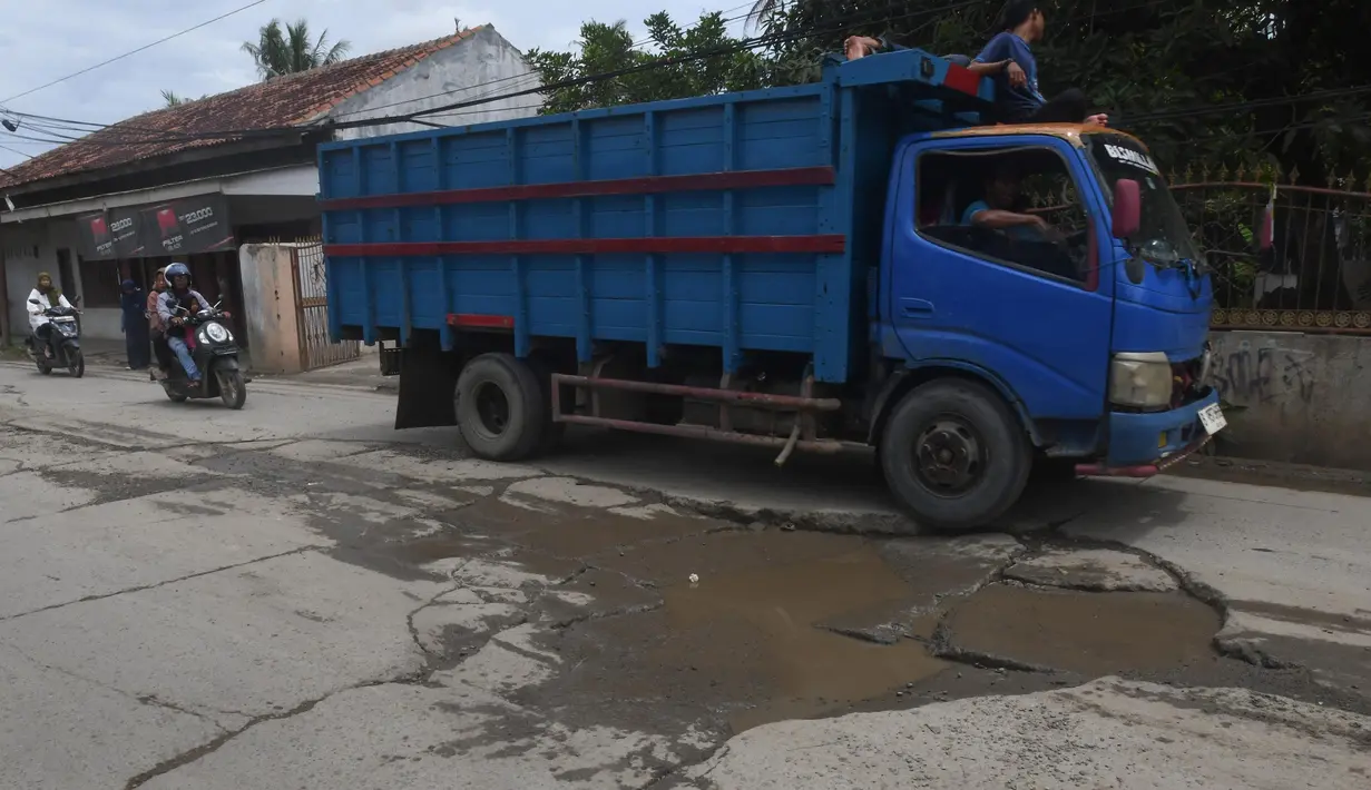 Kerusakan terjadi akibat seringnya kendaraan berat pengangkut material melewati jalan tersebut. (merdeka.com/Arie Basuki)