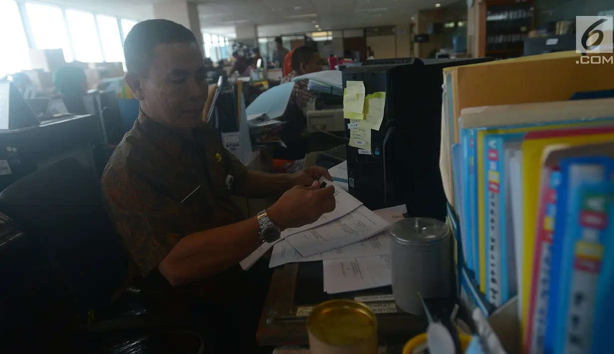 Seorang pegawai merapikan dokumen saat mulai masuk kerja usai libur Lebaran di Balai Kota DKI Jakarta, Rabu (21/6). Usai halalbihalal, pegawai Pemprov DKI mulai berkerja normal. (Merdeka.com/Imam Buhori)