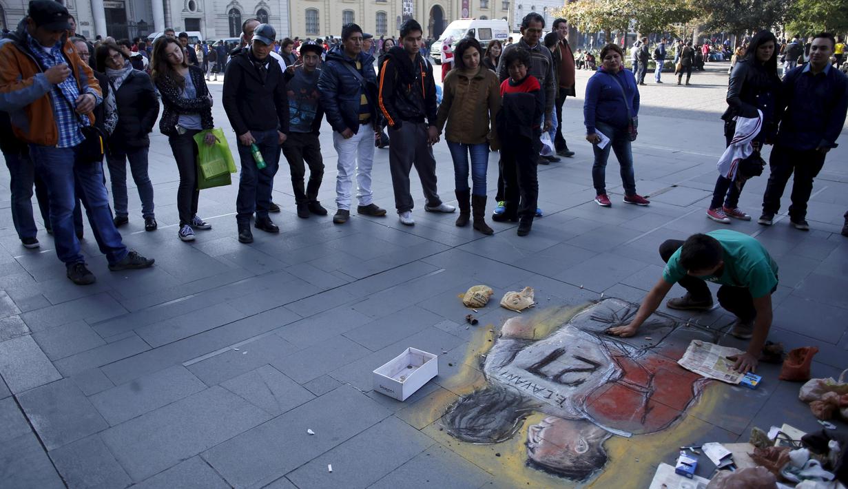 Seniman Chili melukis tindakan provokasi Gonzalo Jara terhadap pemain Uruguay, Edinson Cavani di trotoar jalan di Santiago, Chili (28/6/2015). Hal ini merupakan bentuk protes warga Chili terhadap aksi provokasi Bek Gonzalo Jara. (REUTERS/Marcos Brindicci)
