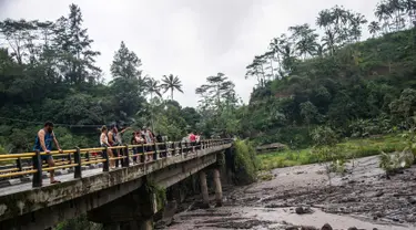 Sejumlah turis melihat aliran lahar dingin Gunung Agung di Karangasem, Bali (29/11). Ribuan turis diperkirakan akan meninggalkan Bali pada 30 November menyusul penutupan bandara akibat Gunung Agung Meletus. (AFP Photo/Juni Kriswanto)