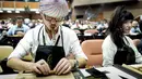 Seorang peserta menggulung cerutu selama kelas master dalam Festival Havana Cigar ke-20 di Istana Konvensi di Havana, Kuba (28/2). (AFP Photo/Adalberto Roque)