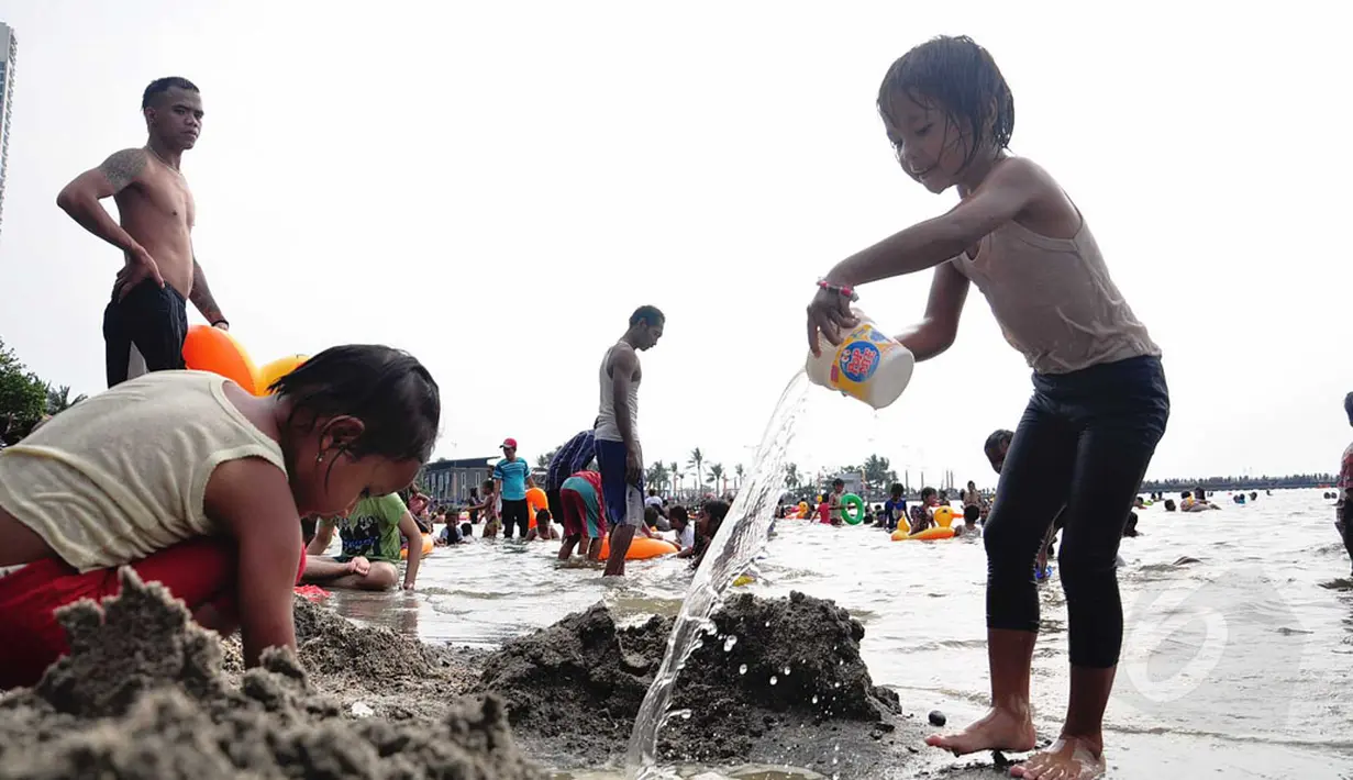 Sejumlah anak terlihat asyik bermain pasir di Pantai Ancol, Jakarta, (30/7/2014). (Liputan6.com/Faizal Fanani)