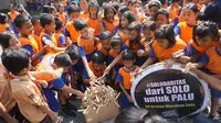 Sejumlah siswa mengumpulkan mainan tradisional othok-othok untuk dikirimkan kepada para korban gempa dan tsunami di Palu dan Donggala, Jumat (12/0).(Liputan6.com/Fajar Abrori)