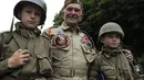 Salah satu veteran Perang Dunia II dari AS, Jack W. Schlegel (tengah), berpose bersama dua pemuda Inggris, Cameron Stevens (kanan) dan Joe Newton di Sainte-Marie-du-Mont, (3/6/2014). (REUTERS/Pascal Rossignol)