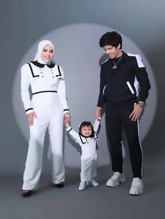 Tampil serasi dengan warna monokrom juga bisa jadi inspirasi. Seperti terlihat pada gaya pasangan Aurelie Hermansyah dan Atta Halilintar. Aurelie mengenakan jumpsuit putih dengan aksen pada bagian bahu, sedangkan Atta mengenakan atasan dan bawahan berwarna serba hitam. Foto: Instagram.