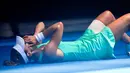 Petenis Prancis, Alize Cornet tergeletak di lapangan akibat cuaca yang begitu panas saat bertanding melawan petenis Belgia Elise Mertens di kejuaraan tenis Australia Terbuka di Melbourne, Australia, (19/1). (AP Photo / Andy Brownbill)