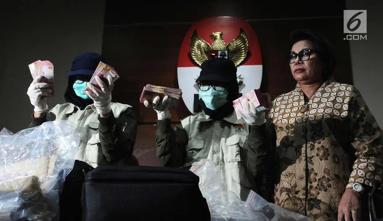 Wakil Ketua KPK, Basaria Panjaitan (kanan) bersama petugas menunjukkan barang bukti hasil OTT Bupati Nganjuk Taufiqurrahman saat rilis di Gedung KPK, Jakarta, Kamis (26/10). KPK menyita uang Rp 298.020.000,-. (Liputan6.com/Helmi Fithriansyah)