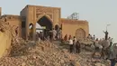 Para warga terlihat berjalan melalui puing-puing makam Nabi Yunus setelah dihancurkan dalam serangan bom oleh militan Negara Islam Irak dan Suriah (ISIS), (24/7/14) (REUTERS/Stringer)