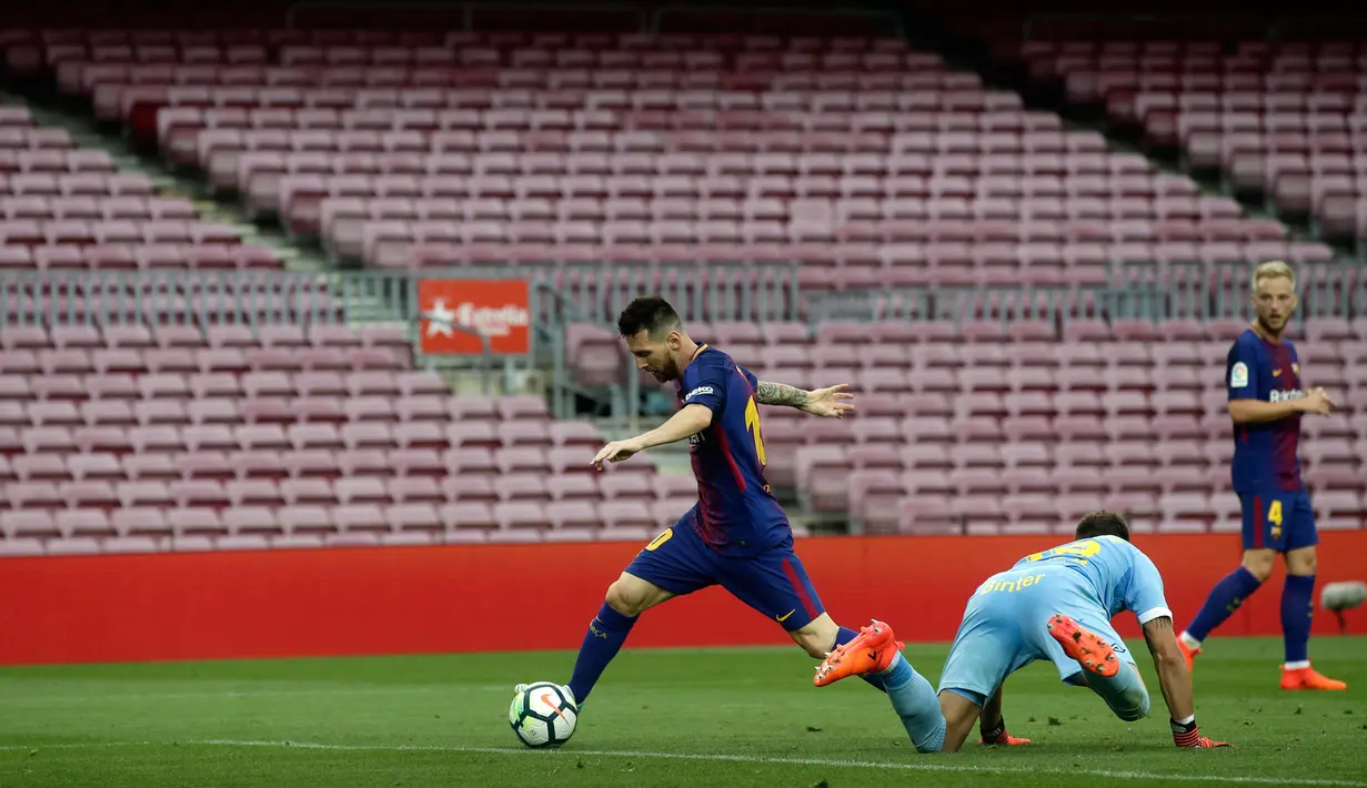 Pemain Barcelona, Lionel Messi berhasil melewati kiper Las Palmas sebelum mencetak gol kedua pada pertandingan Liga Spanyol di Camp Nou, Senin (2/10) dini hari. Dua gol Messi mewarnai kemenangan Barcelona3-0. (AP/Manu Fernandez)