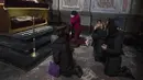 Istri (tengah) dari prajurit Tereshko Volodymyr berusia 44 tahun (kedua kanan) berdoa dan berduka atas kematiannya sebelum upacara pemakaman, setelah meninggal dalam aksi, di Gereja Rasul Suci Petrus dan Paulus di Lviv, Ukraina barat, Senin, 4 April 2022. (AP Photo/Nariman El-Mofty)