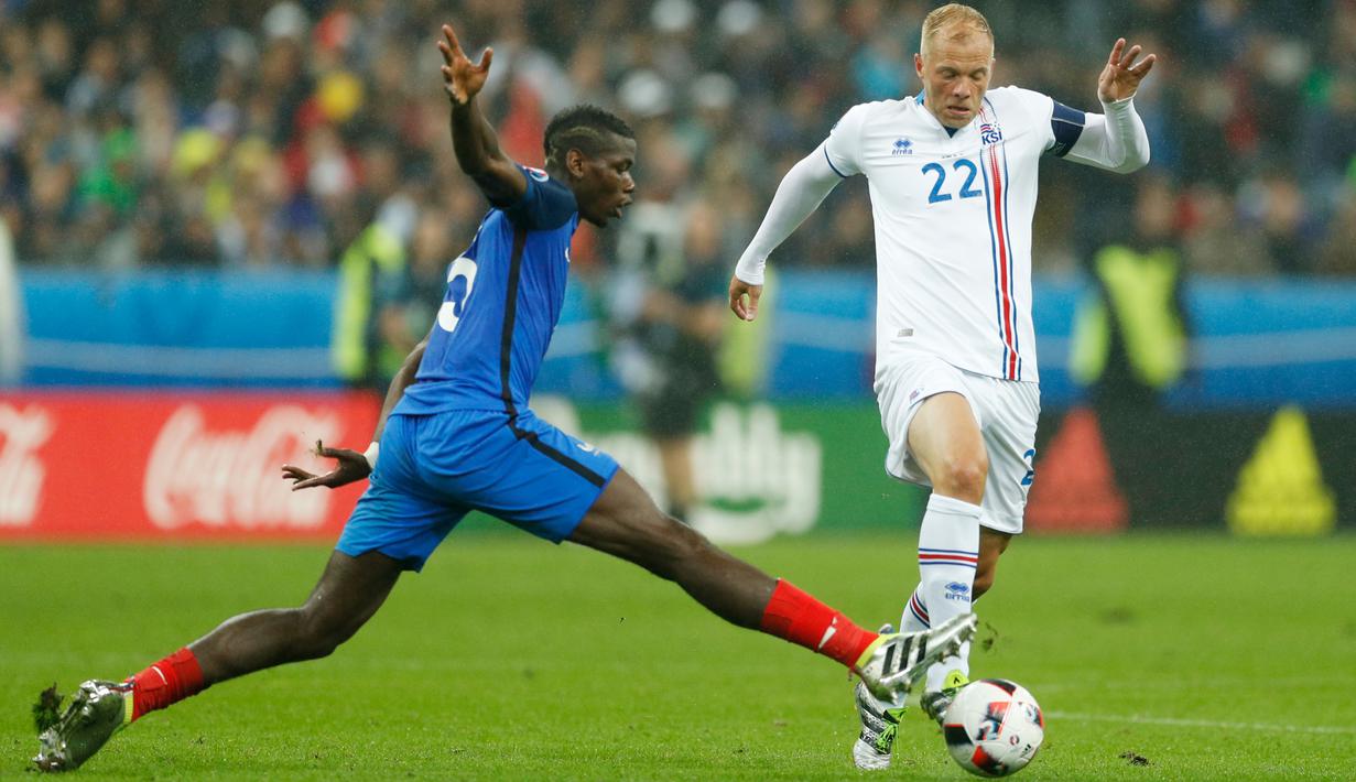 Gelandang Prancis, Paul Pogba (kiri) berusaha merebut bola gelandang Islandia, Eidur Gudjohnsen pada perempat final Piala Eropa di Stade Velodrome, Perancis, (3/7). Prancis akan bertemu Jerman pada semifinal Euro 2016. (REUTERS/John Sibley) 