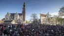 Warga merayakan Hari Raja dekat Gereja Westerkerk (belakang) di pusat Kota Amsterdam, Belanda, Selasa (27/4/2021). Pihak berwenang mendesak warga untuk tetap berpegang pada peraturan jarak sosial COVID-19. (AP Photo/Peter Dejong)