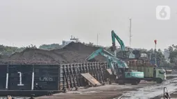 Aktivitas kendaraan alat berat saat bongkar muat batu bara di Pelabuhan PT KCN Marunda, Jakarta Utara, Rabu (5/1/2022). Pelarangan eskpro batu bara tercantum dalam surat nomor B-1605/MB.05/DJB.B/2021 yang dikeluarkan pada 31 Desember 2021 lalu. (merdeka.com/Iqbal S. Nugroho)
