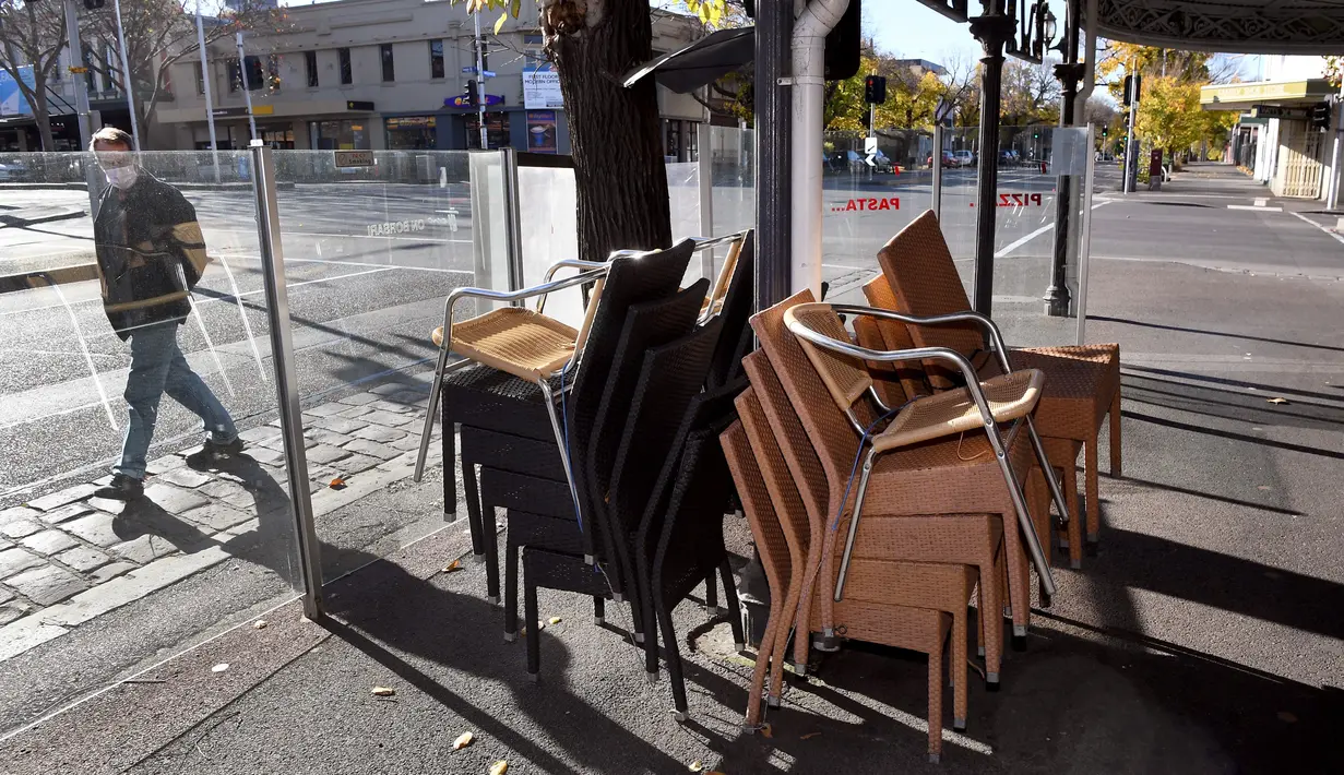 Kursi kafe ditumpuk di kawasan Lygon Street di Melbourne, Rabu (2/6/2021). Pelaksana tugas Menteri Utama Victoria James Merlino mengumumkan lockdown akan diperpanjang tujuh hari lagi, setelah ada enam kasus baru menjadikan total 60 kasus positif hingga hari Rabu (2/6). (William WEST / AFP)
