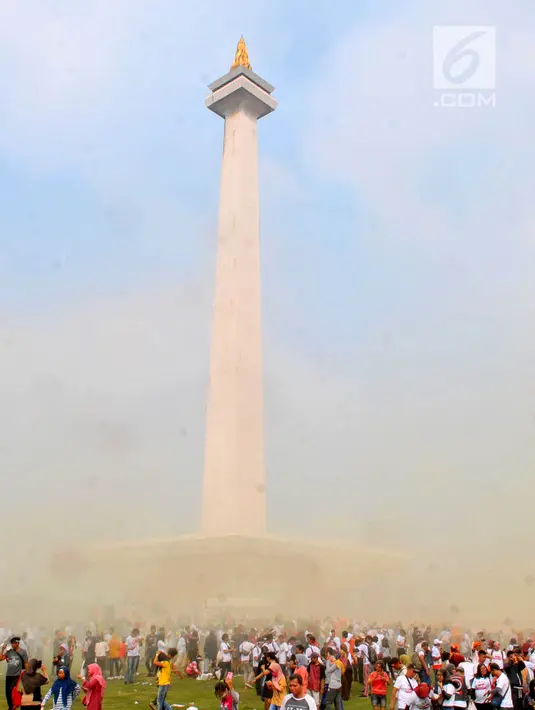 Suasana saat warga bermain serbuk warna-warni saat Festival Damai Millenial Road Safety di Monas, Jakarta, Minggu (23/6/2019). Serbuk warna-warni yang ditembakkan oleh meriam menambah kemeriahan Festival Damai. (merdeka.com/Iqbal Nugroho)