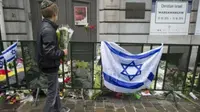 Orang-orang meninggalkan bunga di luar Museum Yahudi di Brussel sebagai penghormatan kepada mereka yang terbunuh pada 24 Mei 2014. (AFP)